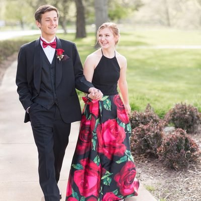 Prom 2019 Dress Ideas from a girl in a high neck floral print prom dress holding hands with her date in tux