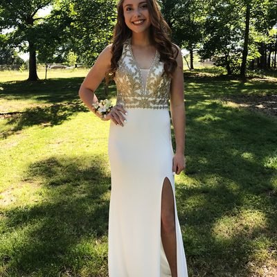 Prom 2019 Dress Ideas from a girl in a white and gold metallic prom dress with skirt slit